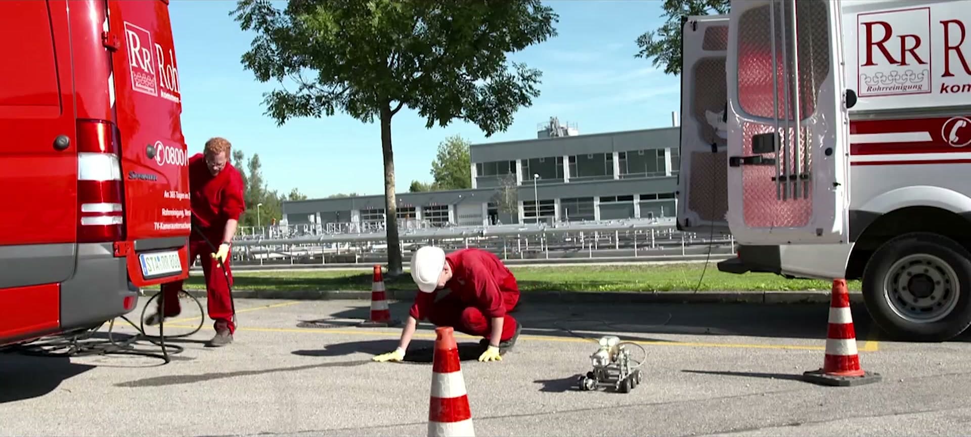 Rohr-Royal Einsatz: zwei Monteure setzen einen TV-Kamera-Roboter in einen Kanalschacht ein